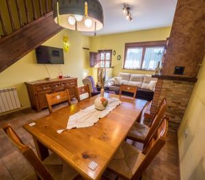 a dining room and living room with a wooden table at Casa Rural El Serrano in Prioro