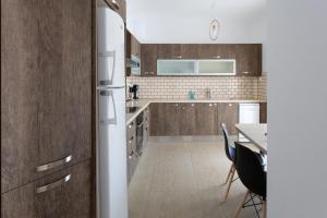 a kitchen with a refrigerator and a table with chairs at Paros Central house in Parikia