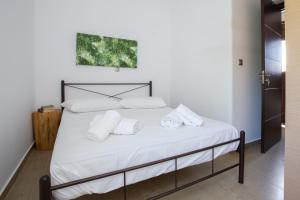 a bedroom with a bed with white sheets and pillows at Paros Central house in Parikia