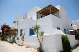 a white building with a palm tree in front of it at Paros Central house in Parikia