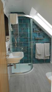 uma casa de banho com um lavatório e uma cabina de duche em vidro. em Breakish Escape B&B-near Broadford em Breakish