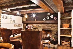 un soggiorno con camino in pietra e sedia di Hostal Cisco de Sans ad Andorra la Vella