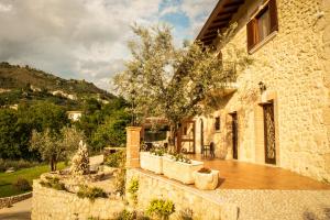 a stone house with a wooden deck in front of a building at Il Casale Della Regina in Arpino