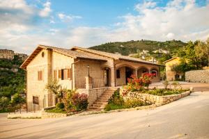 a house on a street with a hill in the background at Il Casale Della Regina in Arpino