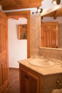ein Bad mit einem Waschbecken und einem Spiegel in der Unterkunft AT Restaurante El Palacil in Vélez-Blanco