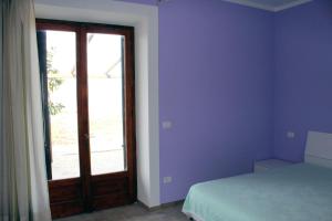 a bedroom with a bed and a door with a window at Struttura Turistica Villa Calamita in Capoliveri