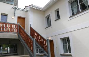 a white building with a staircase in front of it at Arcachon Balsamo plage in Arcachon