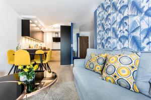 克拉科夫的住宿－Blue Apartment，客厅配有蓝色的沙发和桌子