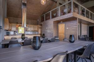 Cette chambre comprend une grande table et des chaises en bois. dans l'établissement Alten Lodge, à Alta