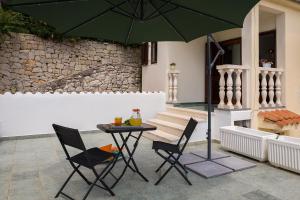 a table and chairs with a green umbrella on a patio at "NM" Luxury apartments in Split