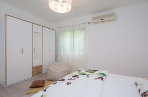 a white bedroom with a bed and a white cabinet at "NM" Luxury apartments in Split