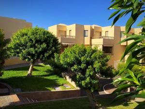 an apartment building with trees in front of it at Villa Ocean Beach in El Médano