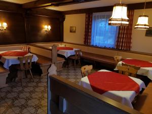 a dining room with two tables and a bench at Haus Alpenland in Sankt Andrä im Lungau