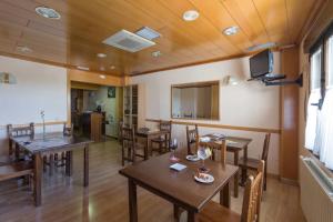 Un comedor con mesas y sillas de madera. en Hostal Arribes del Duero, en Fermoselle