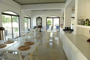 una sala da pranzo con tavoli, sedie e finestre di Apollon Resort a Pythagóreion