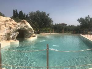 a swimming pool with a rock in the water at Tenuta Contessa - Relais & Spa in Montalto Uffugo
