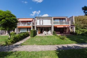 uma vista exterior de uma casa grande com um quintal em Ferienwohnung Westerlicht - Apartment am Leuchtturm - De Torenhoeve em Nieuw-Haamstede