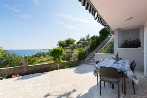a patio with a table and a view of the ocean at Apartment Goga Sevid in Sevid