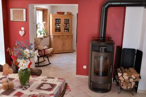 a living room with a stove and a table with flowers at Eden des choux in Krautergersheim