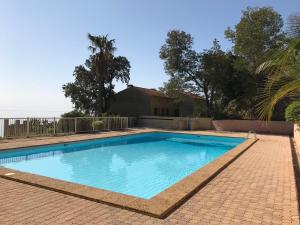 - une piscine en face d'une maison dans l'établissement Appartement - Résidence Le Paradou, à Rayol-Canadel-sur-Mer