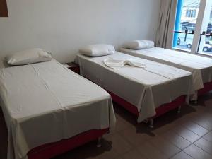 two beds sitting next to each other in a room at Hotel Danubio in Itabaiana