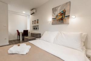 King's Street Apartments في زغرب: غرفة نوم بيضاء مع سرير أبيض وطاولة