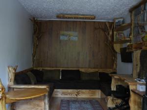 salon z kanapą i drewnianymi ścianami w obiekcie SZARVASKŐ NYARALÓ/ DEER ROCK COTTAGE w mieście Ostrzyhom