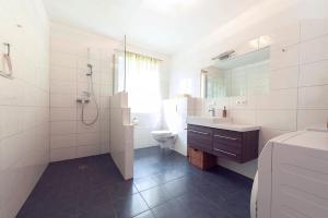 W łazience znajduje się toaleta, umywalka i prysznic. w obiekcie Haus am See w mieście Döbriach