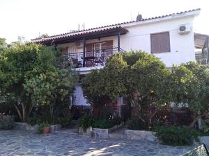 a white house with a balcony and trees at Stelios Studios in Megali Ammos