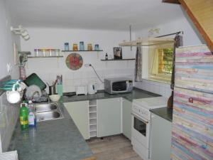 małą kuchnię ze zlewem i kuchenką mikrofalową w obiekcie SZARVASKŐ NYARALÓ/ DEER ROCK COTTAGE w mieście Ostrzyhom +37 zdjęć
