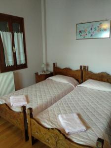two twin beds in a bedroom with a window at Village House in Agios Lavredios