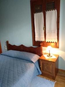 a bedroom with a bed and a night stand with a lamp at Village House in Agios Lavredios