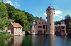 a castle in the middle of a body of water at Aulbach' s Appartments in Leidersbach