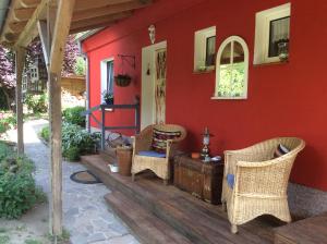 プットブスにあるFerienhaus Namatiriの籐の椅子と赤い家のあるパティオ