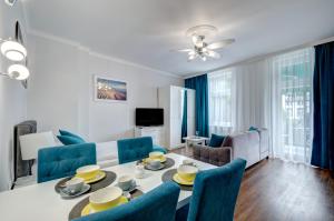 ソポトにある3 City Apartments - Solaroのリビングルーム(テーブル、青い椅子付)