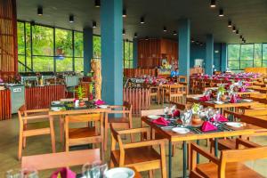 a restaurant with wooden tables and chairs with red napkins at Oak Ray Tea Bush in Ramboda