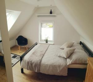 um quarto com uma cama, uma janela e uma cadeira em Ferienhaus Schleeff em Elsfleth