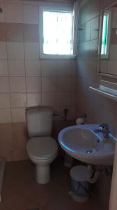 une salle de bain avec toilettes, lavabo et fenêtre dans l'établissement Stelios Studios, à Megali Ammos 39 autres photos