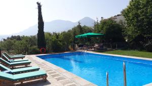 a swimming pool with chairs and a umbrella and mountains at Cabañas Imagina in Torres