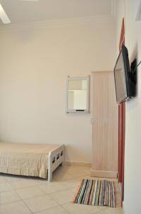 a bedroom with a bed and a flat screen tv at The Garden in Pefki