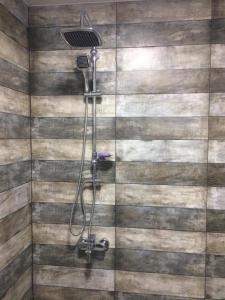 y baño con ducha y pared de madera. en Kvariati G, en Kvariati