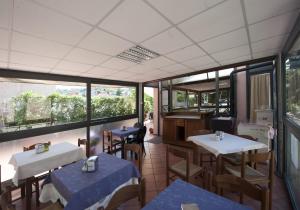 a restaurant with tables and chairs and windows at Hotel Athena in Spoleto