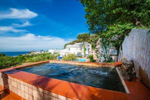 a swimming pool on a patio with the ocean in the background at Bristol Hotel in Ischia