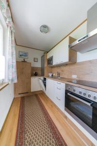 a kitchen with white cabinets and a rug at Das Weinberghaus in Ratsch an der Weinstraße +47 photos