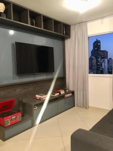 sala de estar con TV en la pared en Apartamento do Lago - São Paulo, en São Paulo