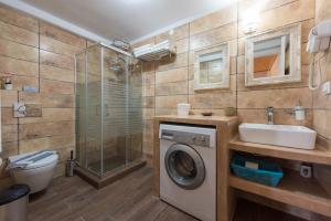 a bathroom with a washing machine and a sink at Geronti Moscha Apartment in Apollonia