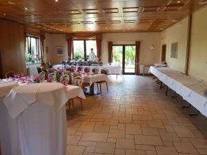 a banquet hall with tables and chairs and a man in the background at Hotel zur Waage in Bad Münstereifel