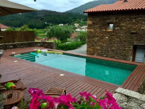 einen Pool auf einer Holzterrasse neben einem Gebäude in der Unterkunft Casa Lia da Pôrta in Caminha