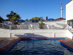 a swimming pool with blue water in front of a building at Hotel Shelter in Mar de Ajó