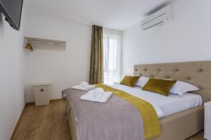 a bedroom with a large bed with towels on it at Pure Relax in Malinska